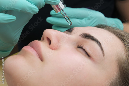 Professional beautician treatment concept. Eyelash lamination, extension performed on beautiful model. Close up portrait, young woman getting eyebrow threading, painting, macroblade shaping procedure.