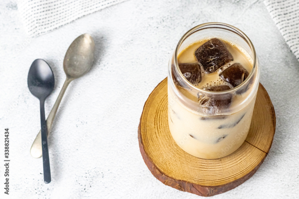 Espresso with milk and frozen coffee cubes on a white stone background Espresso with milk and frozen coffee cubes on a white stone background