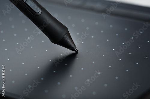 Pen and graphic tablet close-up on a gray textural background. Gadget for working as a designer, artist and photographer. photo