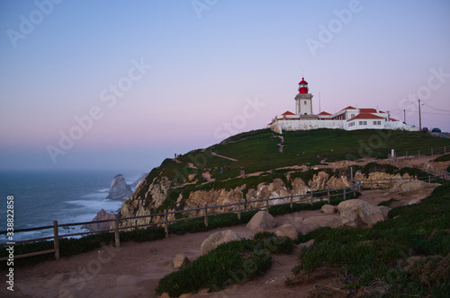 Cabo da Roca, Portugal - white lighthouse on cliffs at evening time.