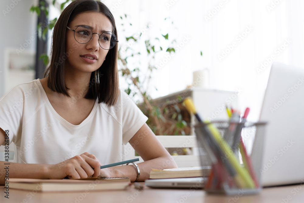 Beautiful young woman working on laptop from home office space Beautiful young woman working on laptop from home office space