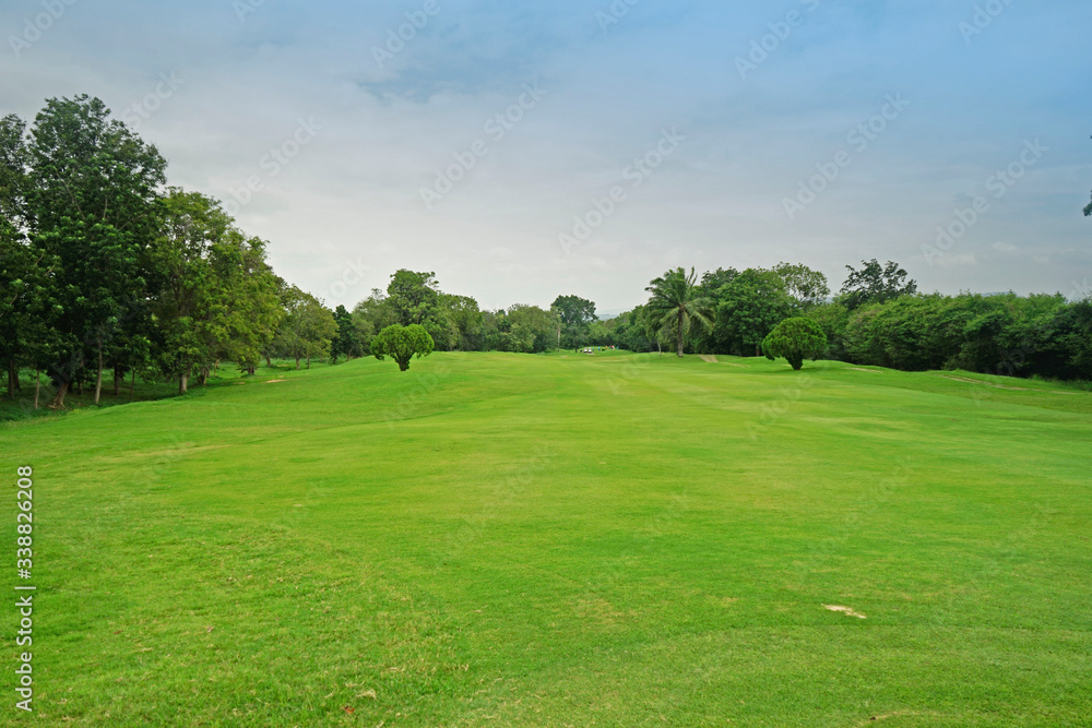 The evening golf course has sunlight shining down at golf course in Thailand