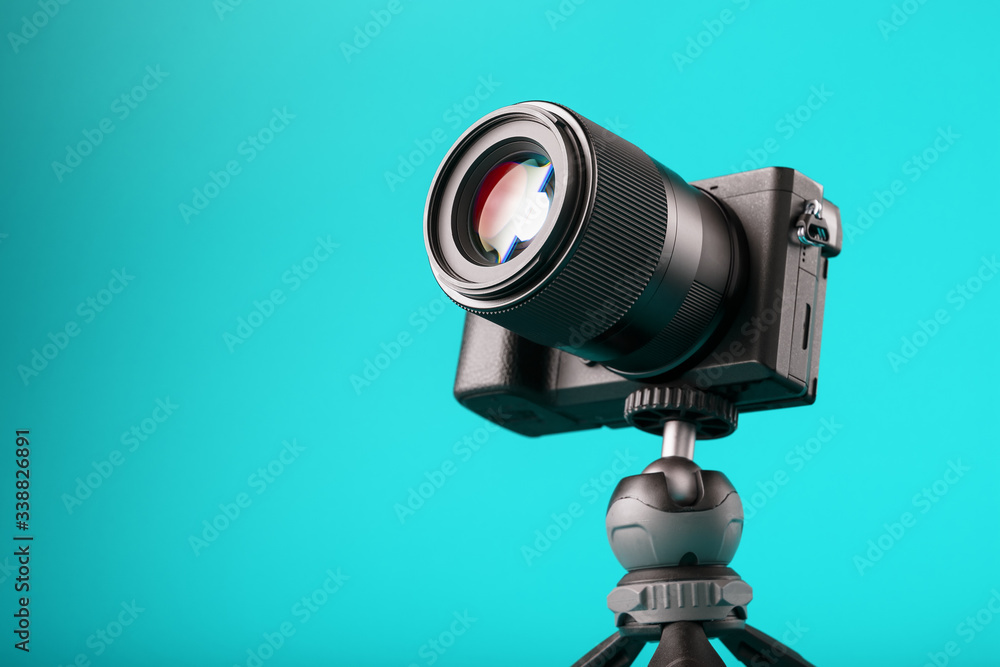 Professional camera on a tripod, on a blue background. Record videos and photos for your blog or report.