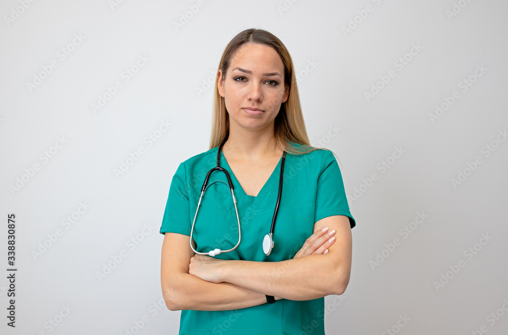 Female nurse standing arms crossed. Confident young woman doctor. Female nurse young pretty woman in green clothes Female nurse standing arms crossed. Confident young woman doctor. Female nurse young pretty woman in green clothes