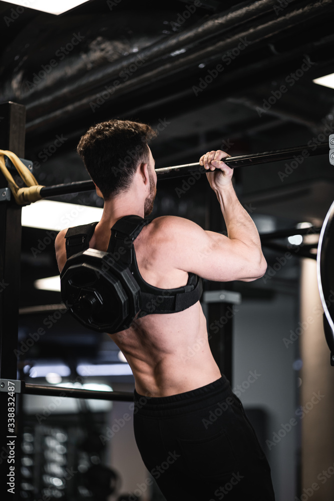 Man during workout in the gym  Concept: power, strength, healthy lifestyle, sport. Powerful attractive muscular Man CrossFit trainer do battle workout with ropes at the gym. Young man exercising using