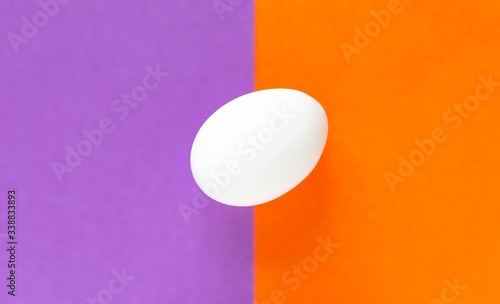 Easter egg on colorful purple and orange split background