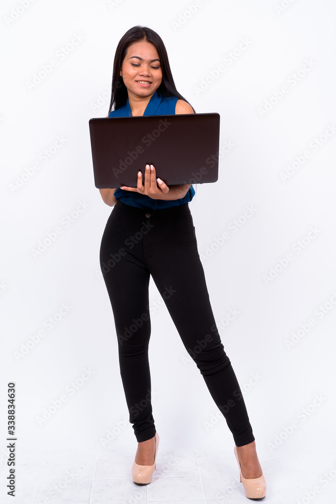 Full body shot of young Asian businesswoman using laptop Full body shot of young Asian businesswoman using laptop