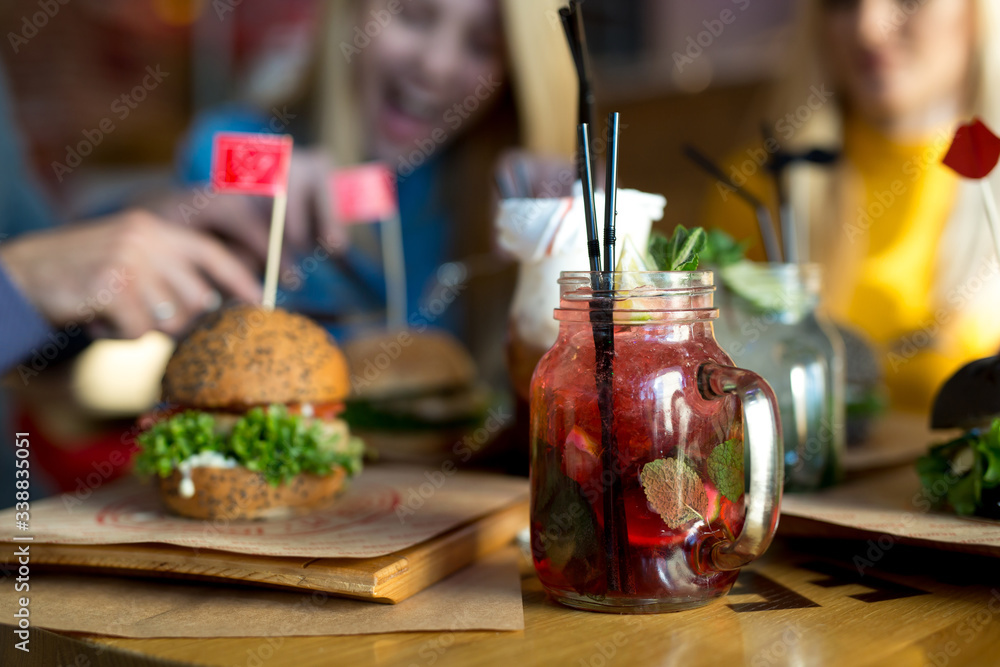 Burgers and cocktails on a wooden table in the restaurant