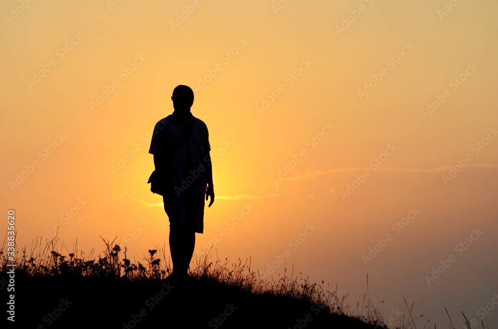 Man Silhouette with Orange Sky and Mountains in the Background.Orange Sunset in the Mountain 