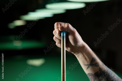 Close up of a unrecognizable man chalking pool cue.