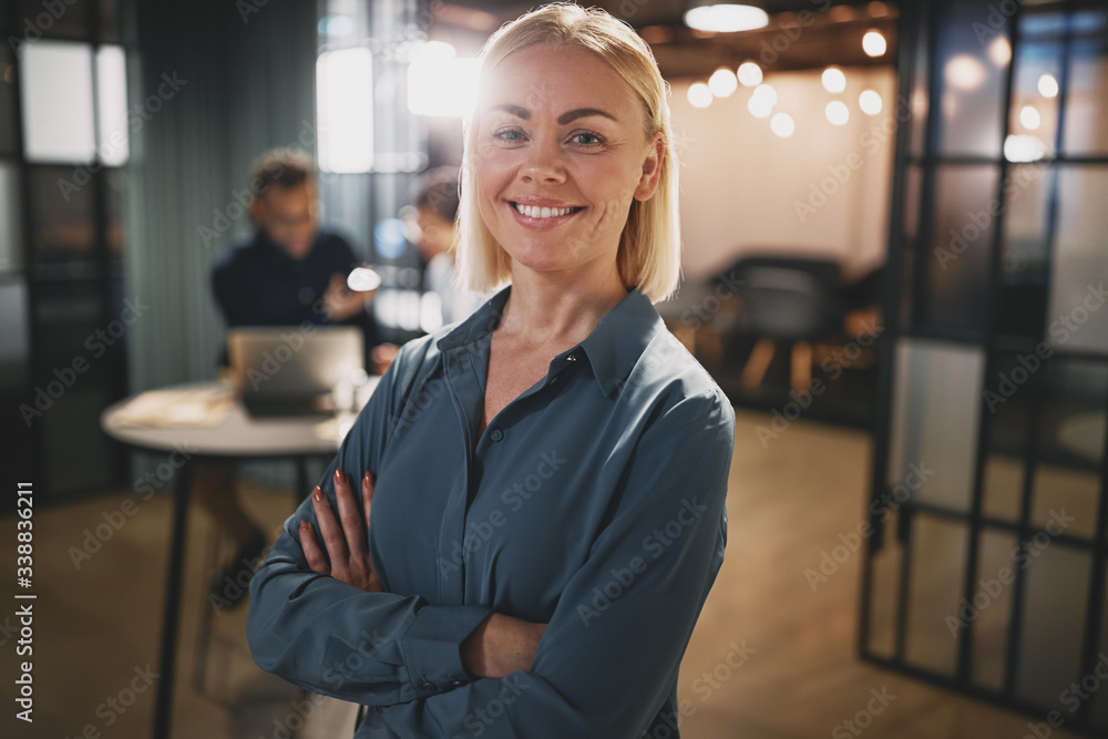 Young businesswoman standing with her arms crossed in an office