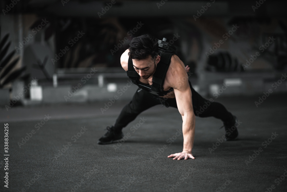 Fototapeta premium Man during workout in the gym Concept: power, strength, healthy lifestyle, sport. Powerful attractive muscular Man CrossFit trainer do battle workout with ropes at the gym. Young man exercising using