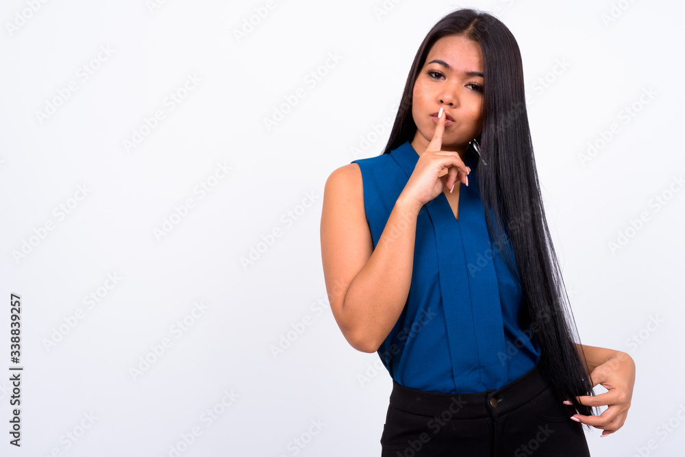 Portrait of young Asian businesswoman with finger on lips Portrait of young Asian businesswoman with finger on lips