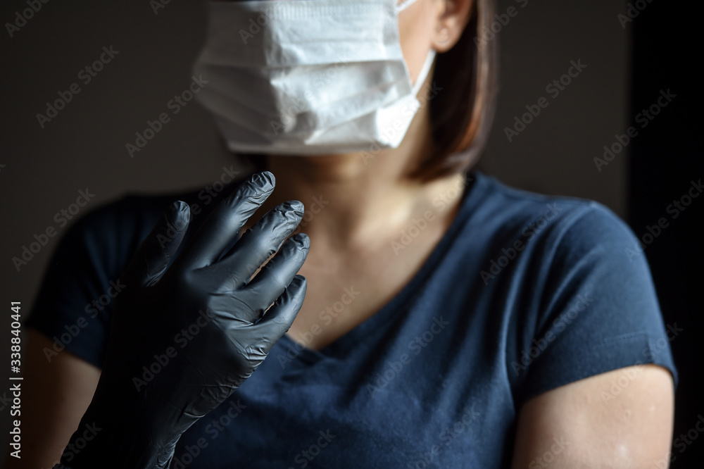 Indoors photo with unrecognizable person wearing black latex medical gloves in times of coronavirus pandemic