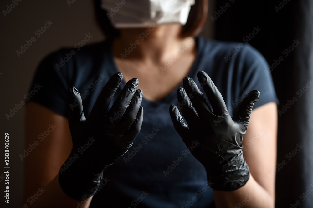 Indoors photo with unrecognizable person wearing black latex medical gloves in times of coronavirus pandemic Indoors photo with unrecognizable person wearing black latex medical gloves in times of coronavirus pandemic