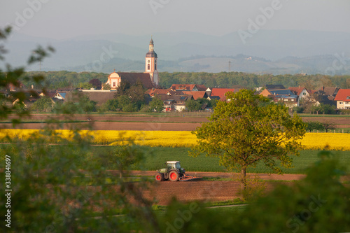 Dorfansicht mit Äcker und Traktor