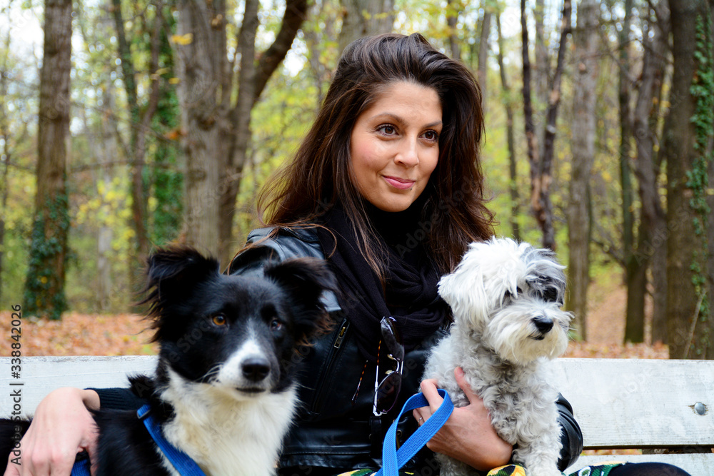 Beautiful Smiling Woman Hugging Her Cute Dogs in the Park .Pets and Owner Outdoor in the Nature Beautiful Smiling Woman Hugging Her Cute Dogs in the Park .Pets and Owner Outdoor in the Nature