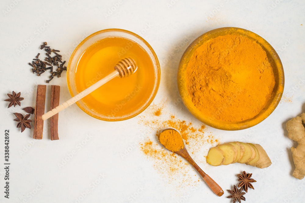 ingredients for Indian traditional Golden milk with turmeric, ginger, spices, honey. healing effect of the drink. antiviral therapeutic antioxidant ingredients for Indian traditional Golden milk with turmeric, ginger, spices, honey. healing effect of the drink. antiviral therapeutic antioxidant