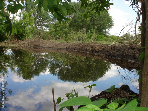 Foto The river is blocked by a fresh earthen embankment dam on a summer day
