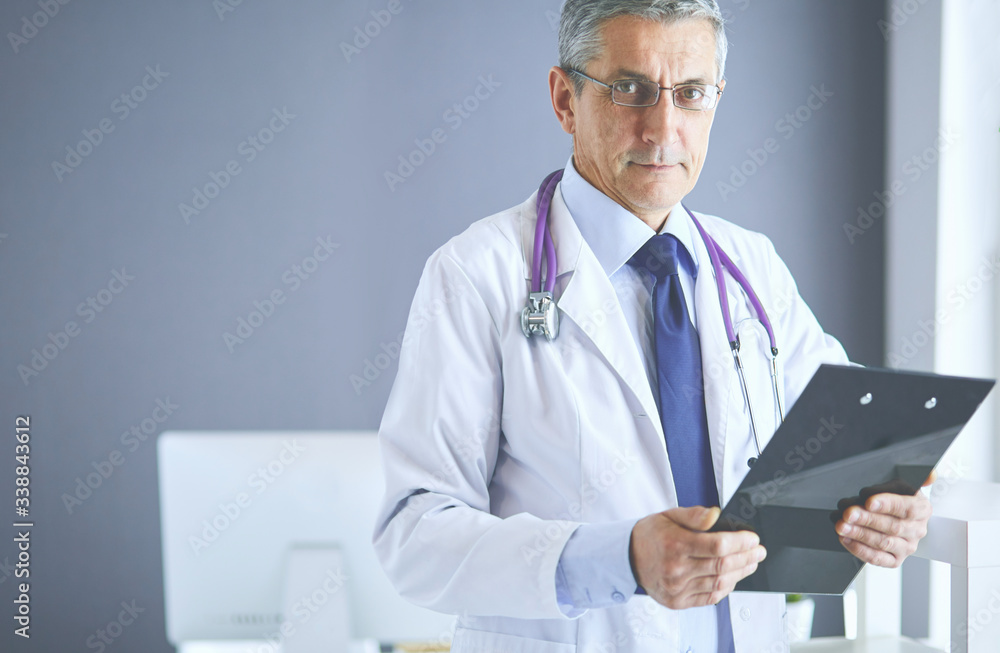 Male doctor writes notes on the clipboard in the hospital Male doctor writes notes on the clipboard in the hospital