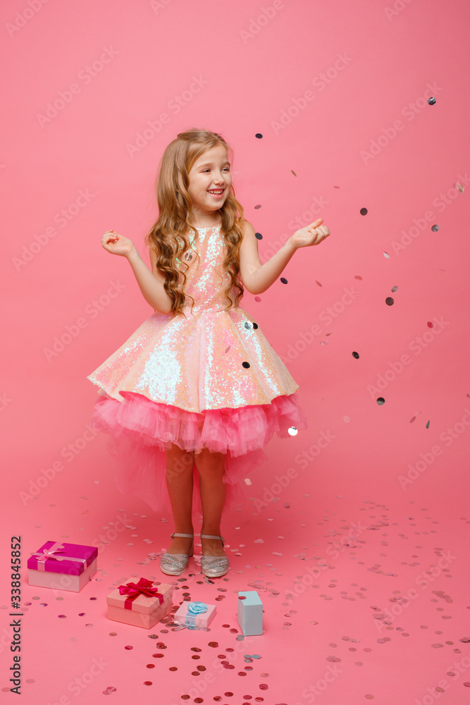 happy Little girl catches confetti on pink background, holiday concept happy Little girl catches confetti on pink background, holiday concept