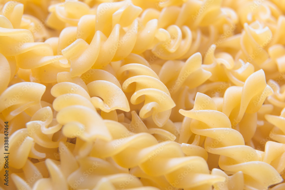Fusilli. / A large quantity of pasta laid flat. the pasta is solid, long, thick, corkscrew or spiral shaped / Fusilli background Fusilli. / A large quantity of pasta laid flat. the pasta is solid, long, thick, corkscrew or spiral shaped / Fusilli background