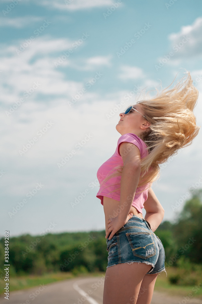 Girl in road, pink t-shirt, blue jeans, happy