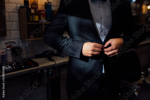 A man fastens a button on a wedding jacket