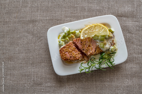 Grilled Tuna steak served with sesame seeds, green slides of asparagus and ro...