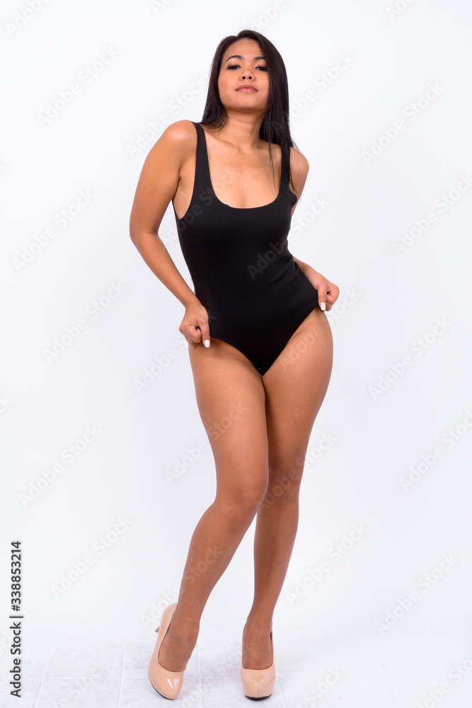 Young Asian woman wearing swimwear against white background Young Asian woman wearing swimwear against white background