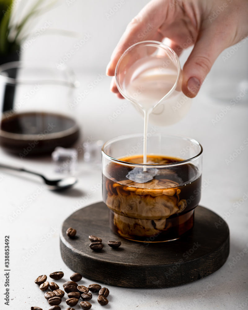 Ice coffee preparation. Cream milk pouring in glass with coffee. Ice coffee preparation. Cream milk pouring in glass with coffee.