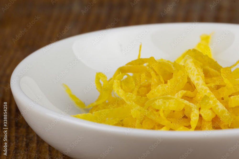 fresh lemon zests in a small white bowl closeup fresh lemon zests in a small white bowl closeup