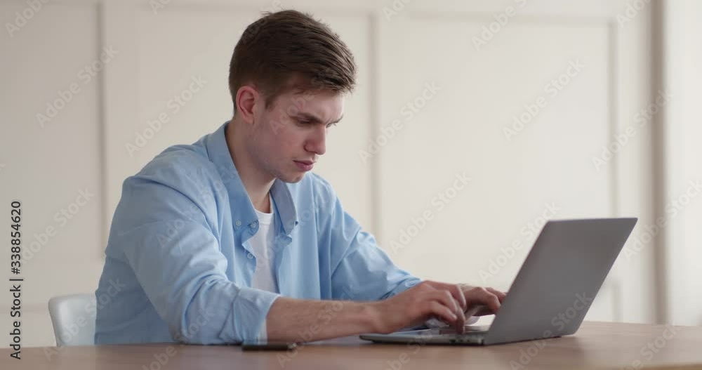 Young frustrated man looking at laptop with error message Young frustrated man looking at laptop with error message