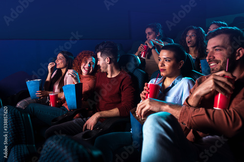 Group of cheerful people laughing while watching movie in cinema. © Zoran Zeremski
