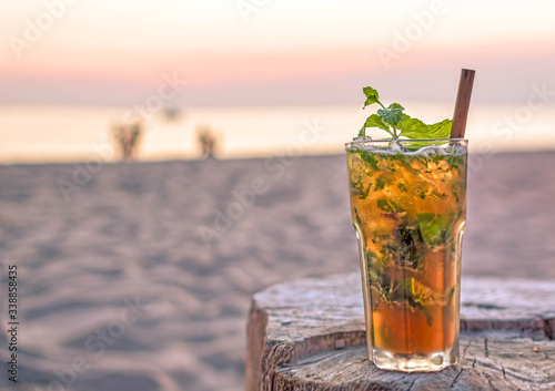 Fototapeta Naklejka Na Ścianę i Meble -  drink with blur beach and sunset in background