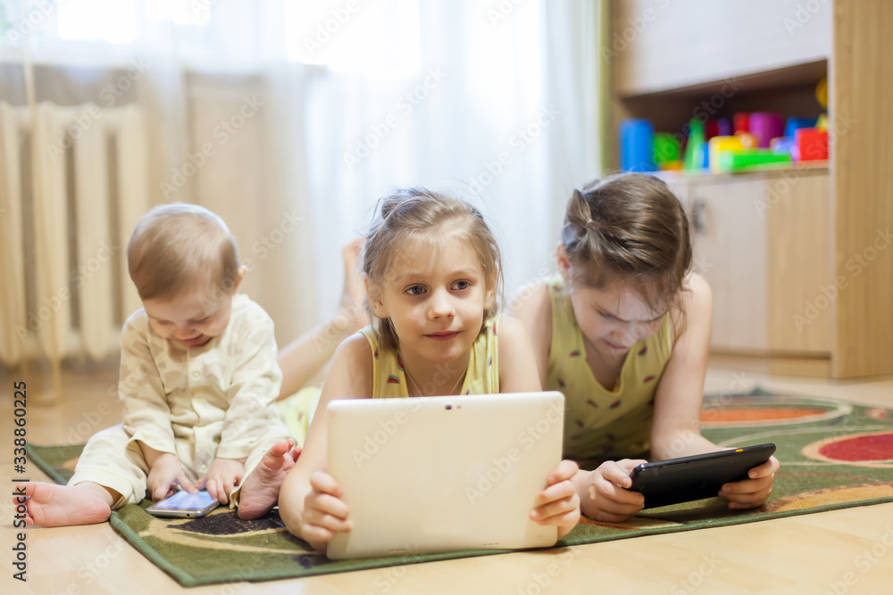 Three sisters sitting at home with tablets Three sisters sitting at home with tablets