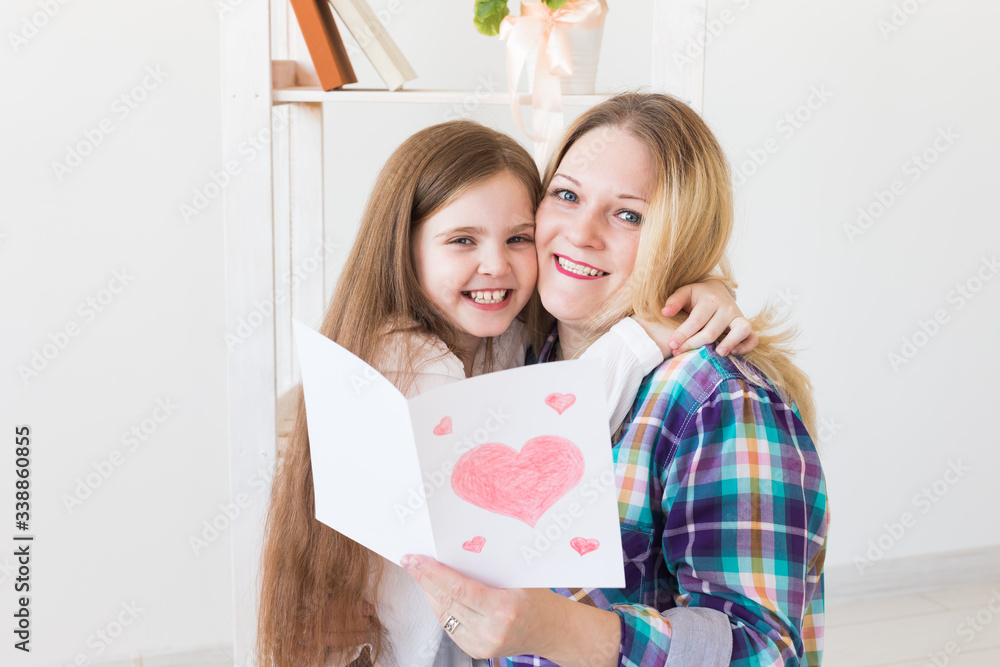 Mother's Day and family holidays - Mother reading greeting card from her daughter. Mother's Day and family holidays - Mother reading greeting card from her daughter.
