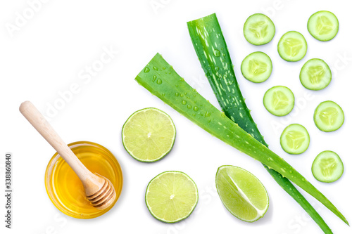 Green fresh aloe vera leaf with cucumber slice, green lime and pure honey isolated on white background. Beauty and spa products concept. Top view. Flat lay. photo