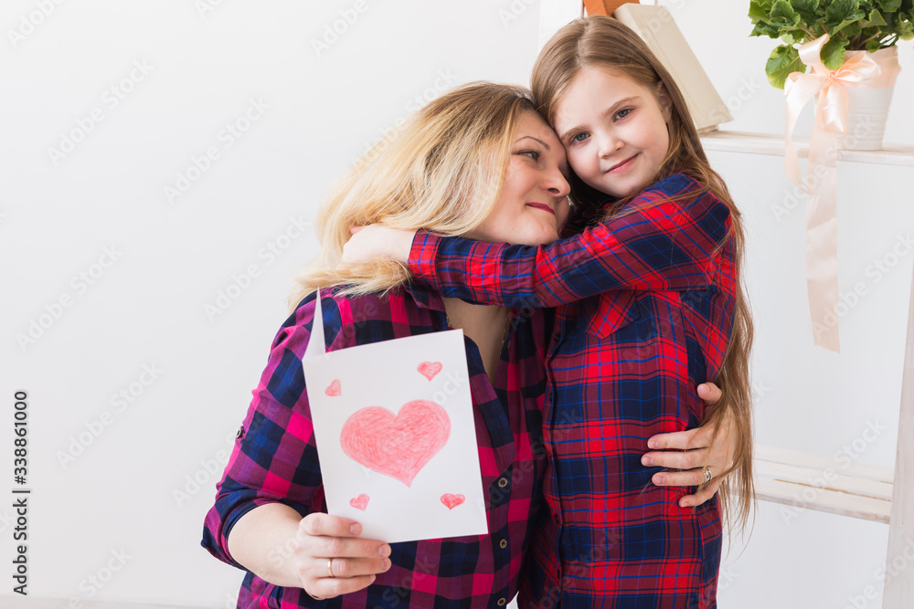 Mother's Day and family holidays - Mother reading greeting card from her daughter. Mother's Day and family holidays - Mother reading greeting card from her daughter.