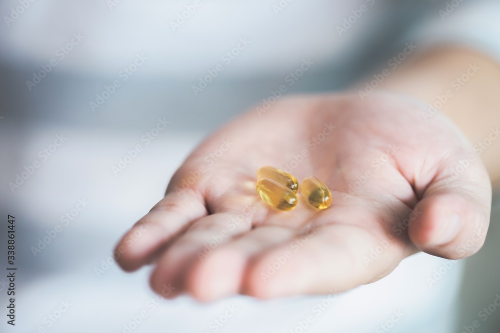 image of yellow pills in hand. image of yellow pills in hand.
