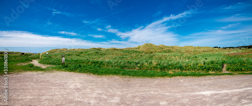 A footpath along dunes from Refsnesstranda beach to a car park in a beautiful sunny day near Naerbo, Norway, May 2018