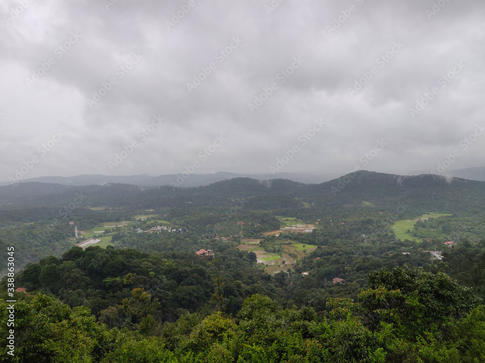 A landscape view of green hills with cloudy sky on the background in Coorg, India. A landscape view of green hills with cloudy sky on the background in Coorg, India.