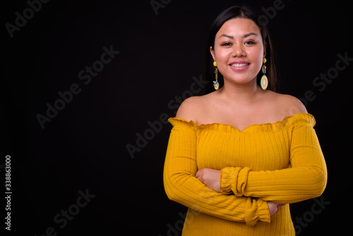 Beautiful overweight Asian woman wearing off shoulder dress photo