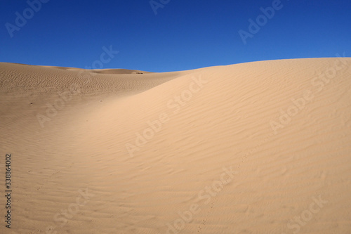 The orange sandy dunes with the trace chain and the blue sky