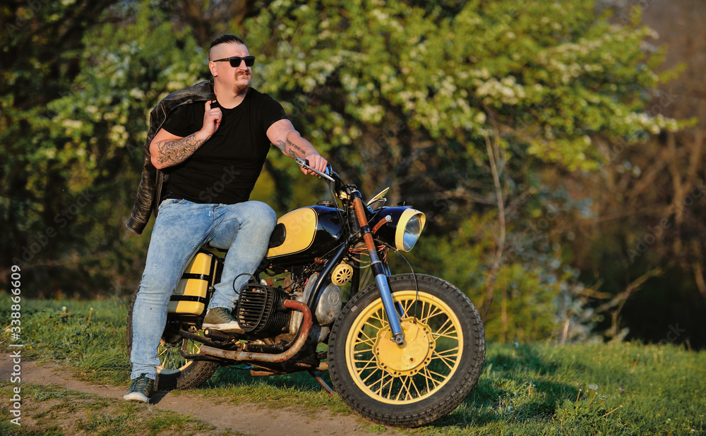 Biker leaning on a motorcycle enjoying the view Biker leaning on a motorcycle enjoying the view