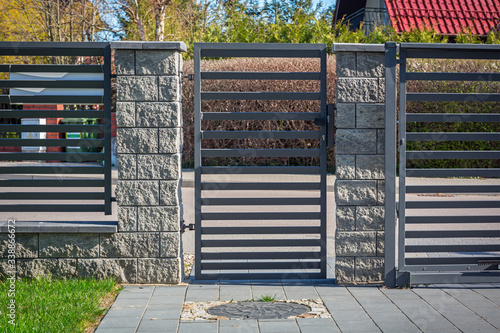 Fotografie Stone fence and entrance gate with remote control