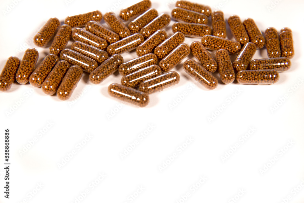 Herb capsule with Brown herbal leaf. Pills in a white background. Copy space