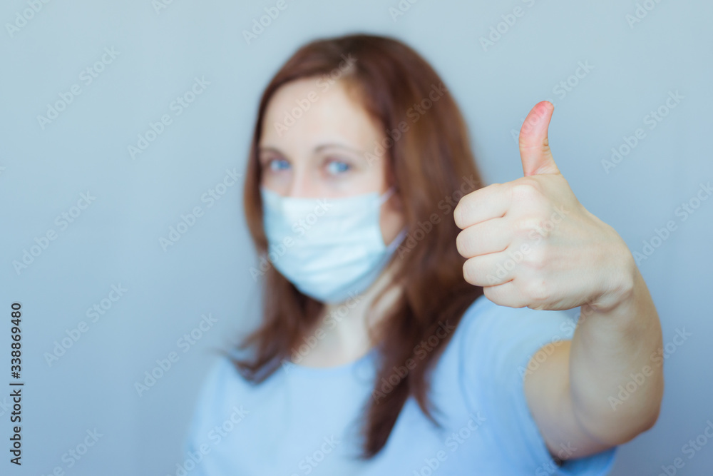 Woman in medical mask showing thumb up. Woman in medical mask showing thumb up.