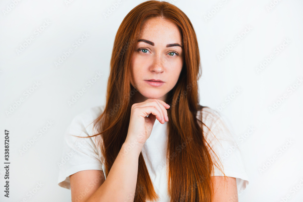 portrait of redheaded young woman looking natural holding hand near her chin on isolated white backgroung, style and beauty concept portrait of redheaded young woman looking natural holding hand near her chin on isolated white backgroung, style and beauty concept