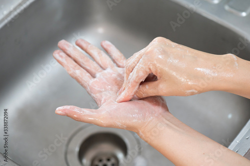 Close up woman hand washing under running water in the kitchen.Hygiene and cleaning Hands.Image hand washing step concept.